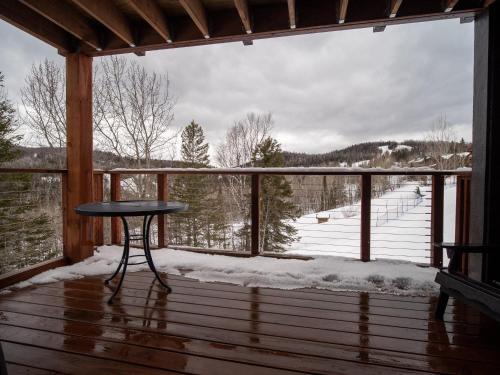 a table on a deck with a view of a snow covered field at Caribou Highlands Lodge in Lutsen