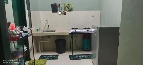 uma pequena cozinha com um lavatório e um fogão em Homestay Lumut em Lumut