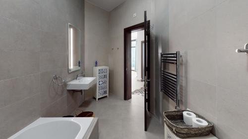 a white bathroom with a sink and a toilet at St Julians Central luxury apartment in St. Julianʼs
