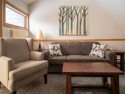 a living room with a couch and a chair and a table at Caribou Highlands Lodge in Lutsen