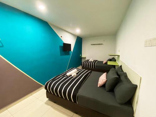 a bedroom with a bed and a blue wall at Hotel 91 Taman Daya in Johor Bahru