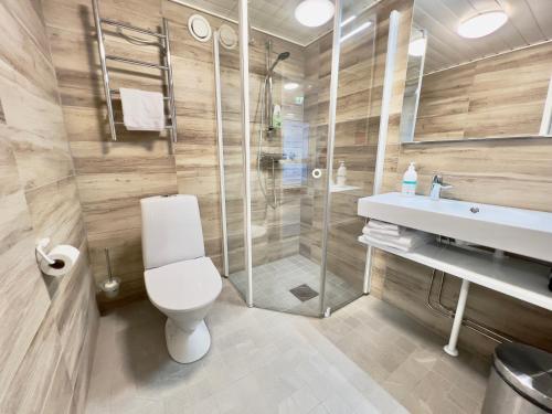 a bathroom with a toilet and a shower and a sink at Hotel Arctic Zone in Ruka