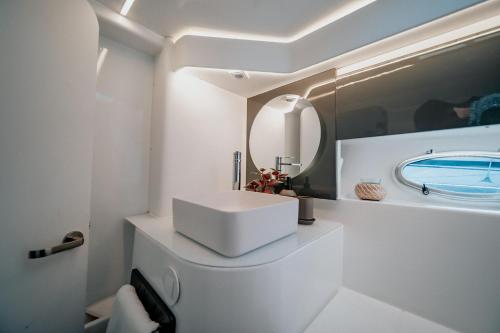 a white bathroom with a sink and a mirror at Valéria, uma noite de sonho in Lisbon