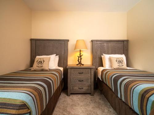 a bedroom with two beds and a lamp on a night stand at Caribou Highlands Lodge in Lutsen