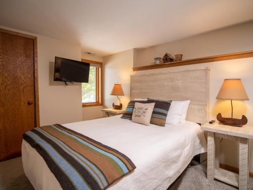 a bedroom with a bed and a flat screen tv at Caribou Highlands Lodge in Lutsen