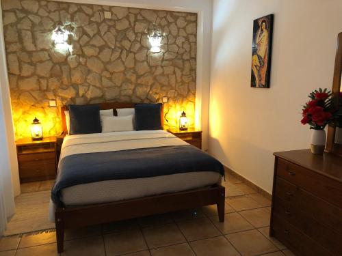 a bedroom with a bed and a stone wall at Casa GiGi in Sagres