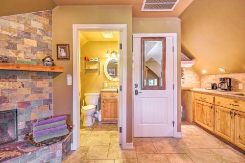 a bathroom with a fireplace and a white door at Romantic Yosemite and Bass Lake Retreat with Mtn Views! in North Fork