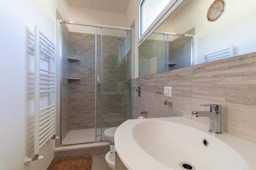 La salle de bains est pourvue de toilettes, d'un lavabo et d'une douche. dans l'établissement Casa Sole e Mare, à Pozzallo