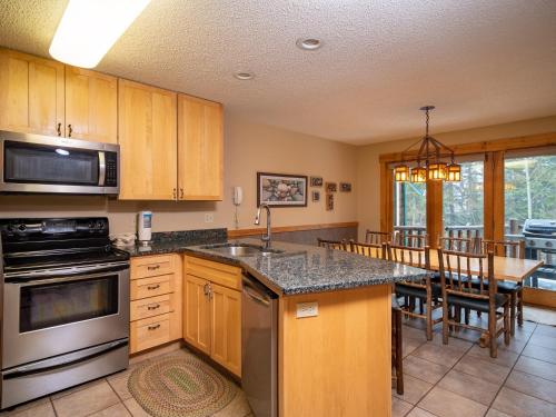 a kitchen with wooden cabinets and a counter top at Caribou Highlands Lodge in Lutsen