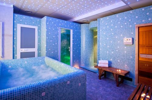 a room with blue tiled walls and a wooden table at Park Hotel La Grave in Castellana Grotte