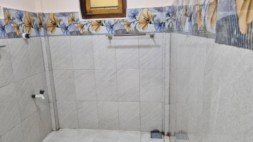 y baño con ducha de azulejos blancos. en Shanvilla, en Jaffna