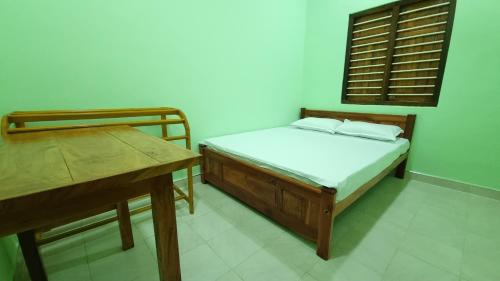Dormitorio pequeño con cama y mesa en Shanvilla, en Jaffna
