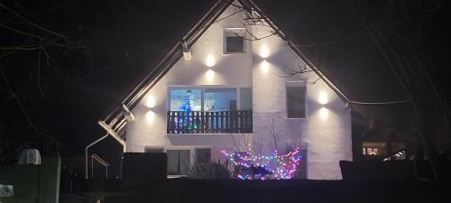 a white house with a window with christmas lights at Vila Jovana in Vrdnik