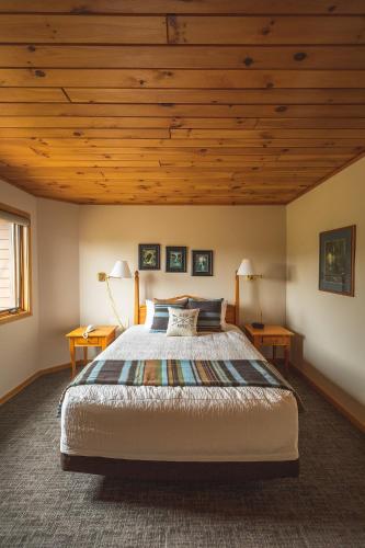 a bedroom with a large bed and wooden ceilings at Caribou Highlands Lodge in Lutsen