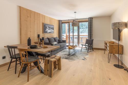 a living room with a couch and a table at Cristal Lodge by Daddy Pool- TERRESENS in Saint-Chaffrey