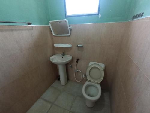 KING TOP Holiday Inn في Monaragala: حمام صغير مع مرحاض ومغسلة