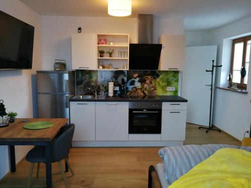 a kitchen with a stove and a table in a room at Quartier No. 7 - Serviced Living in Grödig
