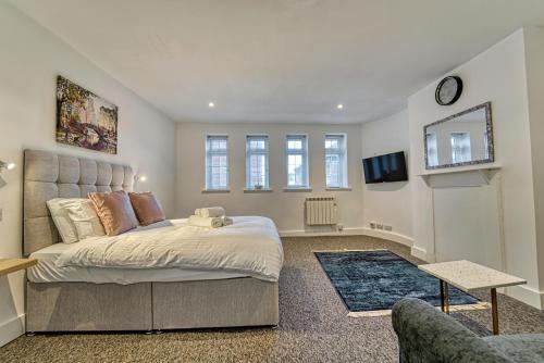 a bedroom with a large bed and a tv at Guest Homes - Hills Apartments in Worcester