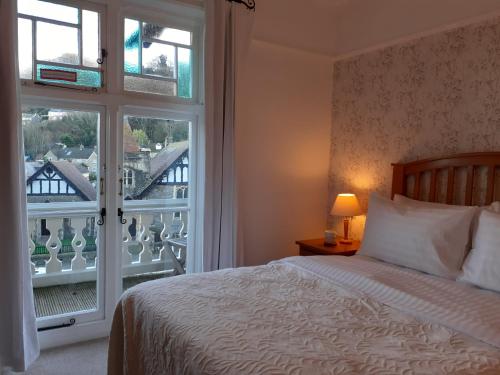 ein Schlafzimmer mit einem Bett und einem großen Fenster in der Unterkunft Gable Lodge Guest House in Lynton