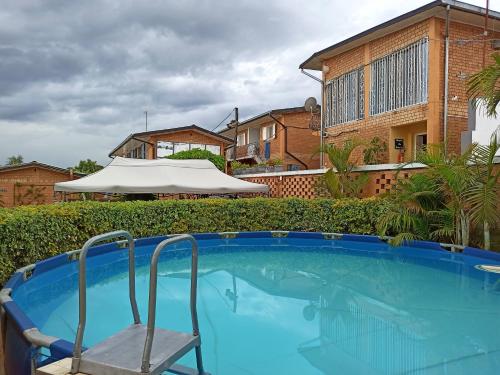 a chair sitting next to a swimming pool with an umbrella at Chez Jeanne Auberge in Talata-maty
