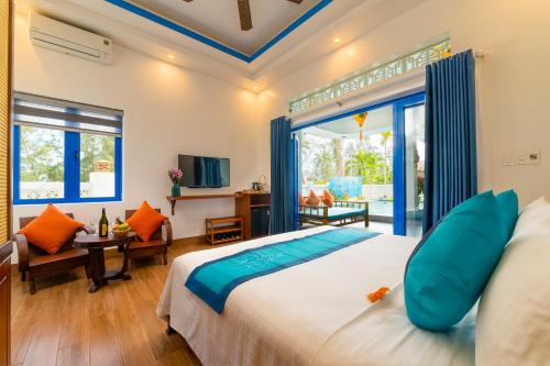 ein Schlafzimmer mit einem großen Bett und ein Wohnzimmer in der Unterkunft LOCAL BEACH FRONT VILLAS in Tân Thành (1)