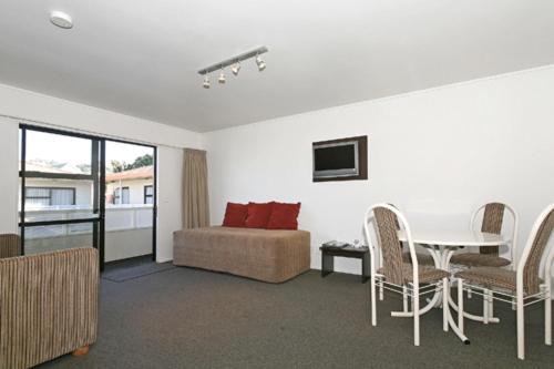 a living room with a couch and a table and chairs at Marksman Motor Inn in Wellington