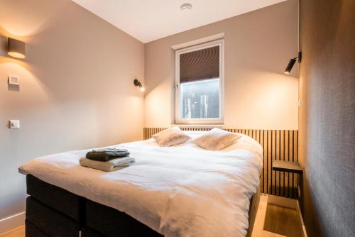 a bedroom with a large bed with a window at Luxe appartement in haven Marina Kamperland - 2 badkamers in Kamperland