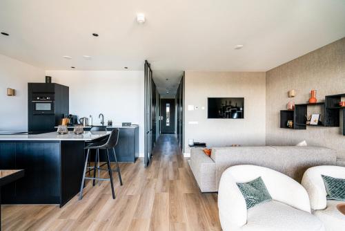 een keuken en een woonkamer met een bank en een tafel bij Luxe appartement in haven Marina Kamperland - 2 badkamers in Kamperland