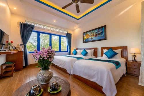 a bedroom with two beds and a table at LOCAL BEACH FRONT VILLAS in Tân Thành (1)