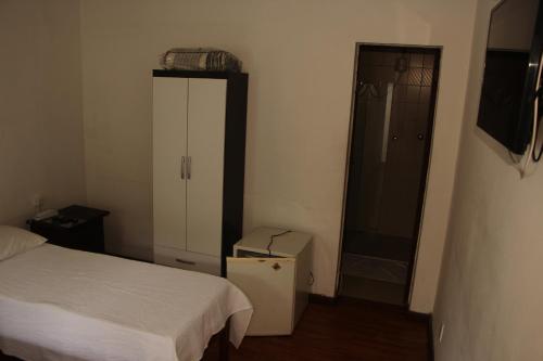 a bedroom with a bed and a closet and a shower at Pousada Villa Real in Sabará