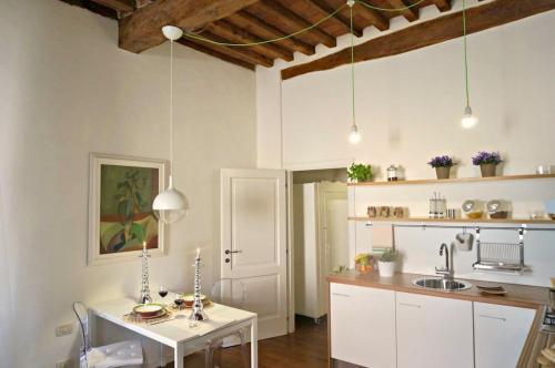 a kitchen with a white table and a sink at Nido Bianco - Sylish Studio in Historic Centre in Vicopisano