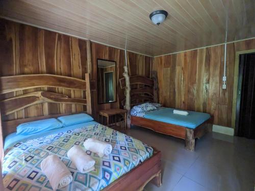 ドラケにあるCorcovado Mountain Houseの木製の部屋にベッド2台が備わるベッドルーム1室