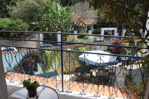 a balcony with a table and chairs and plants at Pousada Villa Real in Sabará