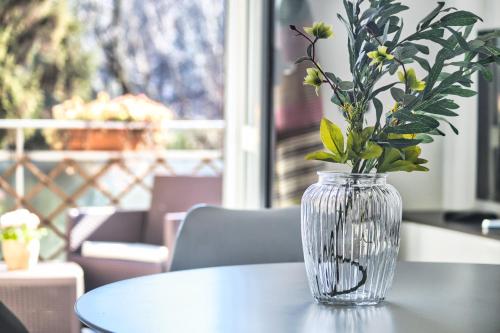 a glass vase with flowers sitting on a table at JOIVY Delightful flat with balcony in Milan