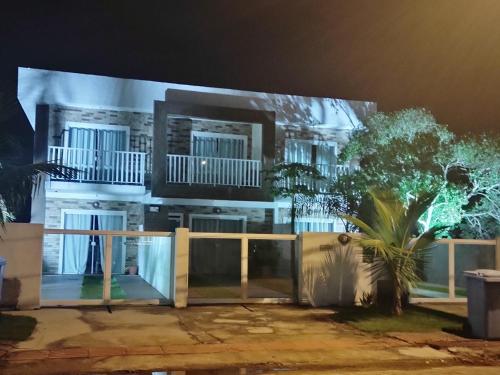 un gran edificio blanco con porche por la noche en Moradas do Campeche CSABC, en Florianópolis