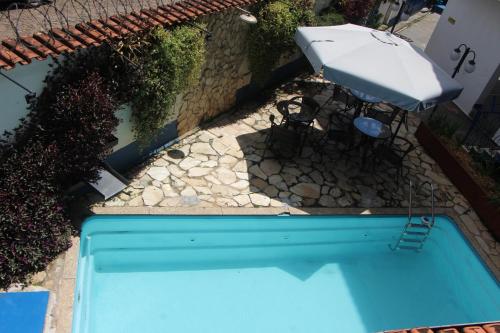 an overhead view of a swimming pool with an umbrella at Pousada Villa Real in Sabará
