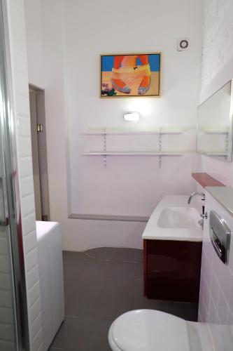 a bathroom with a white toilet and a sink at Art & Design Studios in Budapest