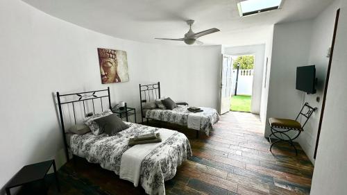 a bedroom with two beds and a ceiling fan at La Duomo di Vulcano in Playa Honda