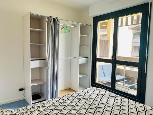 Zimmer mit einem Bett, einem Fenster und Regalen in der Unterkunft Appartement 4 pers max à Seignosse le Penon in Seignosse