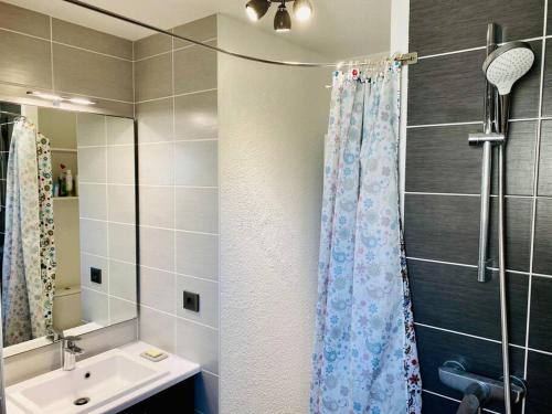 ein Bad mit einem Duschvorhang und einem Waschbecken in der Unterkunft Appartement 4 pers max à Seignosse le Penon in Seignosse
