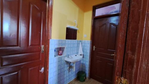 a bathroom with a sink next to a door at Pinnacle Homes in Naivasha