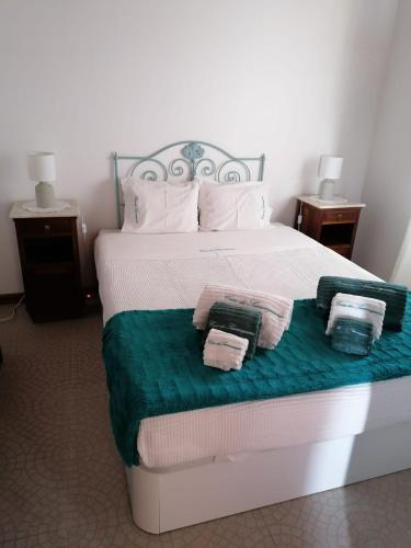 a bedroom with a bed with two towels on it at Casa da Samouqueira in Rogil