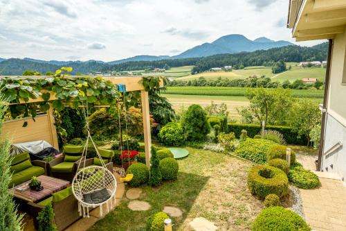 a garden with a swing and a view of the mountains at Relax & Beautiful View in Slovenj Gradec