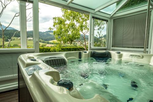 a hot tub in a room with windows at Relax & Beautiful View in Slovenj Gradec