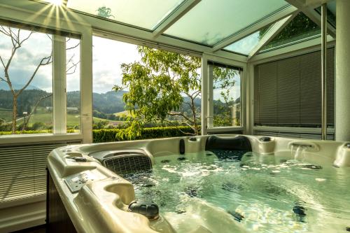 bañera de hidromasaje en una habitación con ventanas en Relax & Beautiful View, en Slovenj Gradec