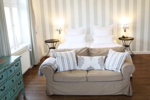 a bedroom with a bed and a couch with pillows at Villa Silbermöwe in Wyk auf Föhr