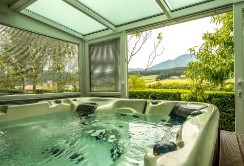 a bath tub in a room with a window at Relax & Beautiful View in Slovenj Gradec