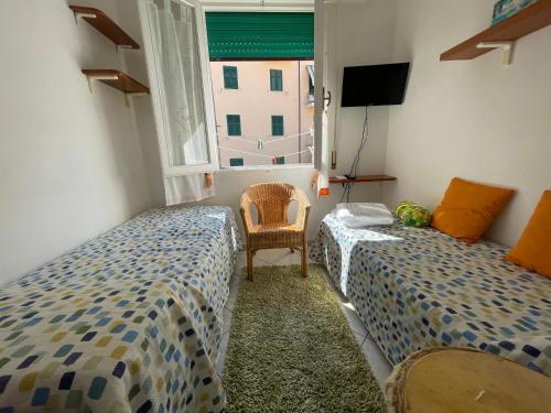 a bedroom with two beds and a window at Giuly's Room in Porto Santo Stefano