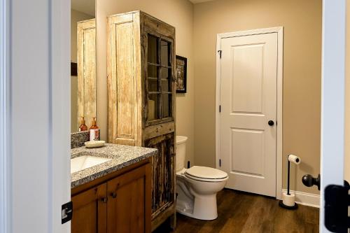 a bathroom with a toilet and a wooden cabinet at Shady Pines in Gatlinburg