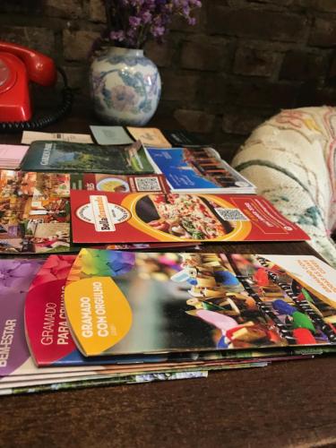 einen Haufen Zeitschriften, die auf einem Tisch liegen in der Unterkunft St. Virginia’s in Gramado